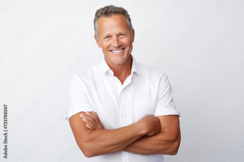 Handsome mature man in casual wear looking at camera and smiling while standing against grey background Handsome mature man in casual wear looking at camera and smiling while standing against grey background