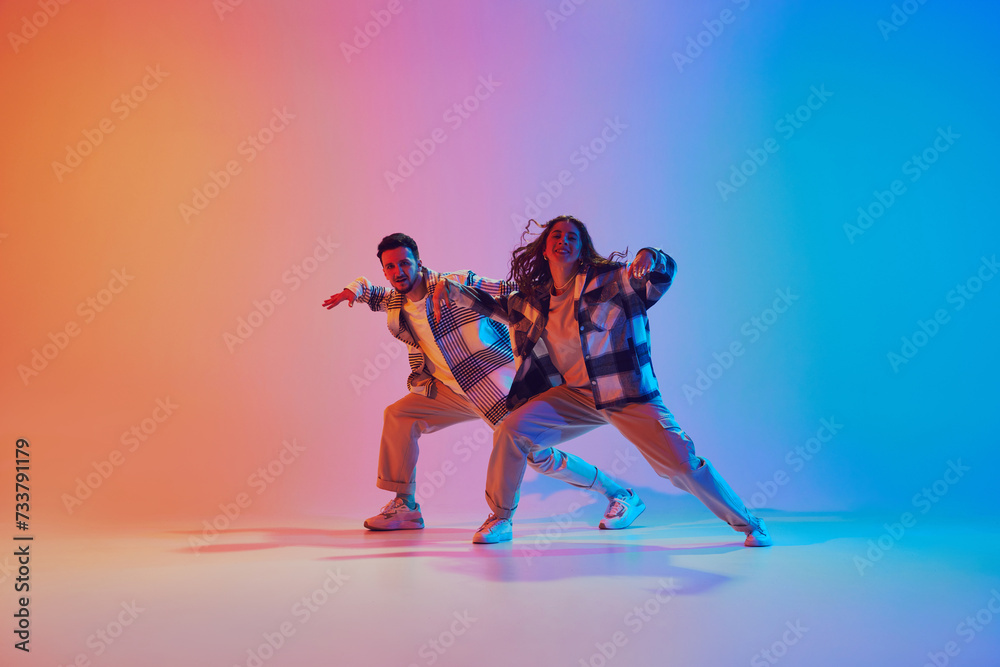 custom made wallpaper toronto digitalMan and woman, dancing synchronously in motion against gradient studio background. Harmony moves. Concept of fashion and style, movement, energy, dance battles. Dynamic gel portrait