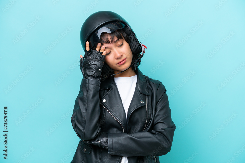 Young Argentinian woman with a motorcycle helmet isolated on blue background with headache Young Argentinian woman with a motorcycle helmet isolated on blue background with headache