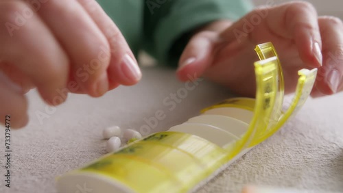 close up view of elderly woman hands sorting pills and medication and puts in tablet box due to prescriptions on table. old people medicare
