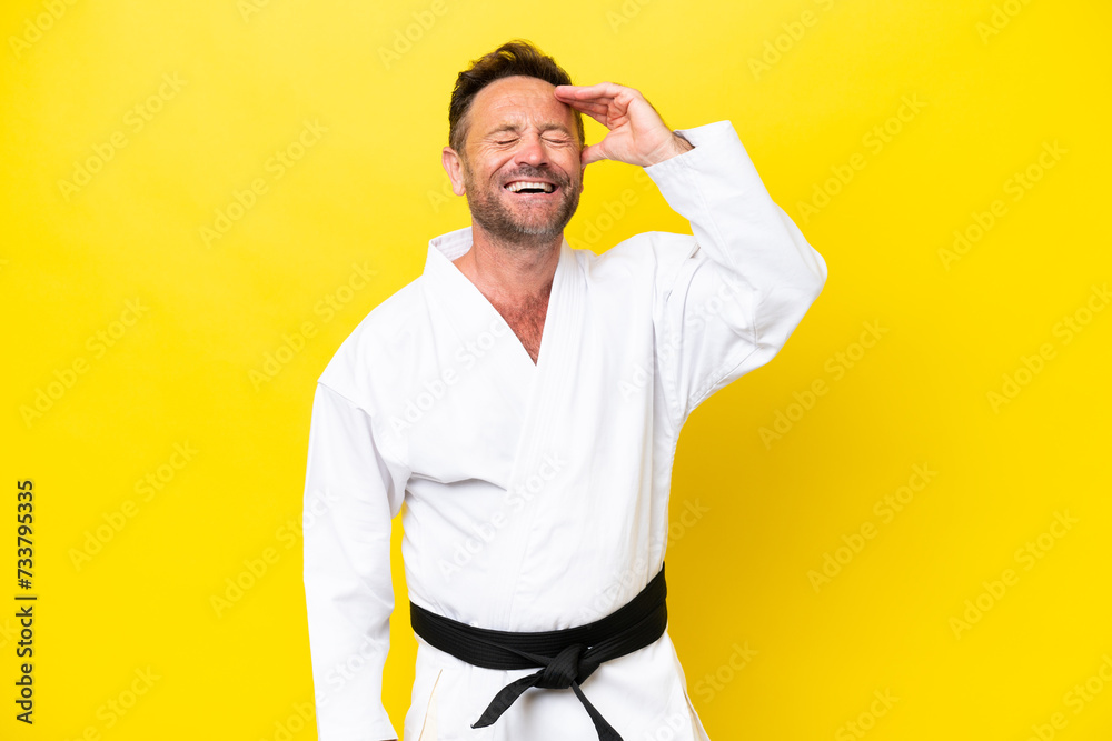 Middle age caucasian man doing karate isolated on yellow background smiling a lot Middle age caucasian man doing karate isolated on yellow background smiling a lot
