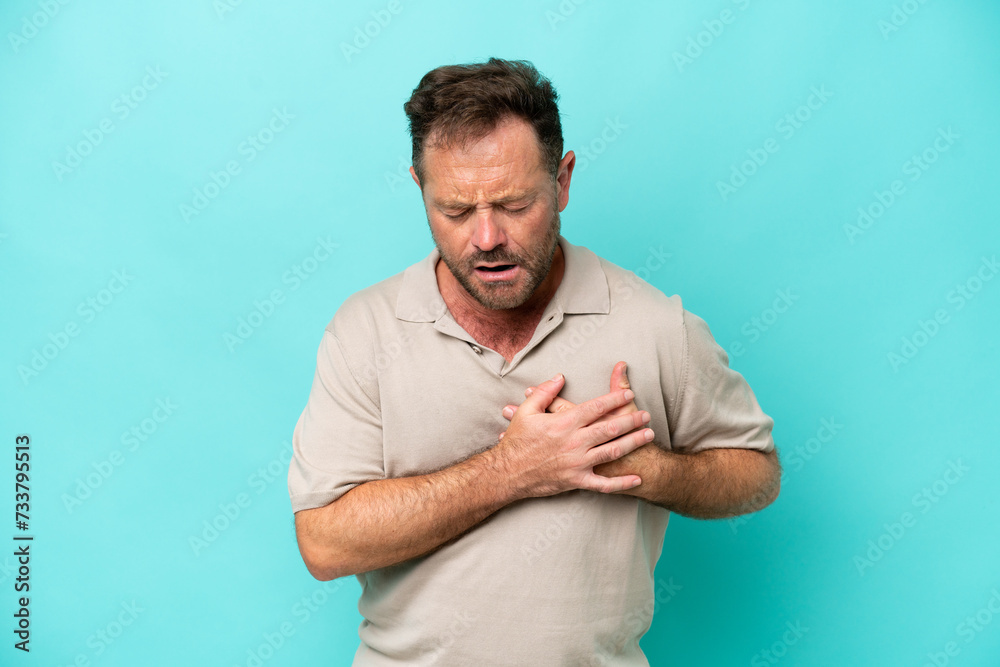 Middle age caucasian man isolated on blue background having a pain in the heart Middle age caucasian man isolated on blue background having a pain in the heart