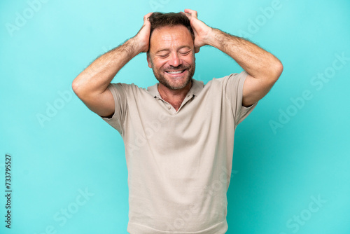 Middle age caucasian man isolated on blue background laughing