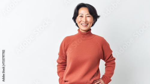 Portrait of positive confident mature asian woman standing over white background.
