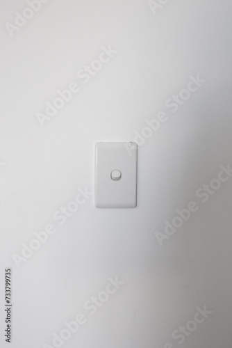 A white switch on the white wall.