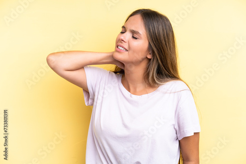 Young caucasian woman isolated on yellow background with neckache