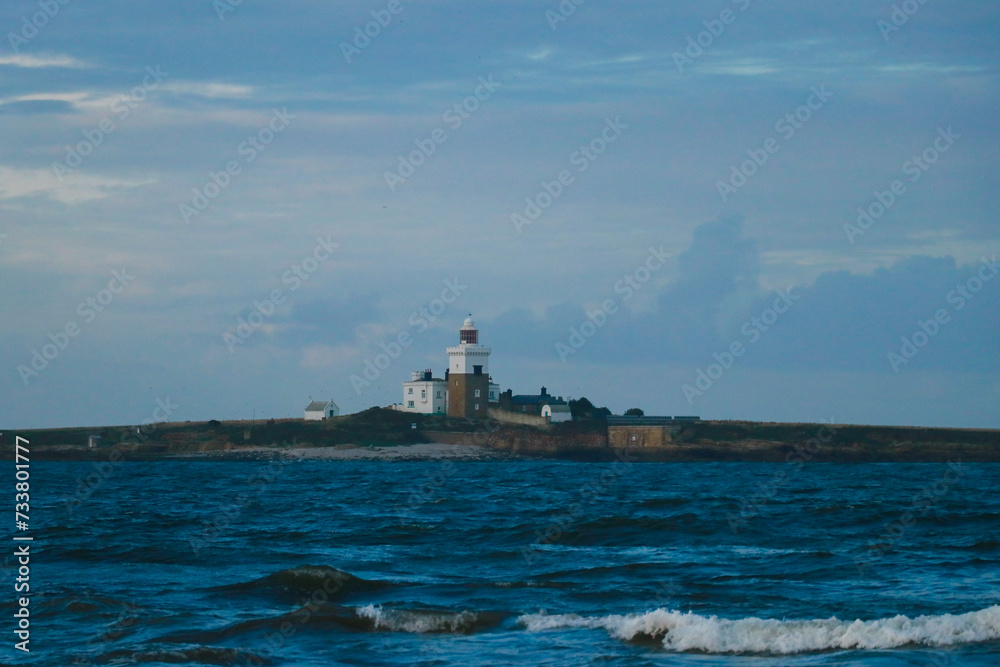 stormy sea with an island with lighthouse