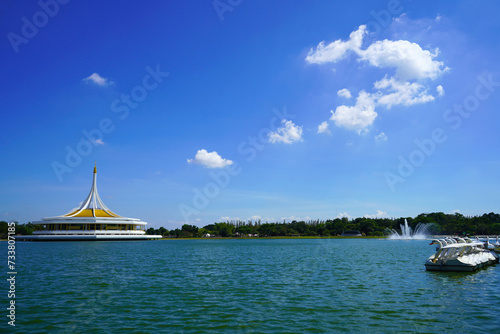 Duck pedal boats are parked in a row floating in a large fountain pond at Suan Luang Rama IX.  