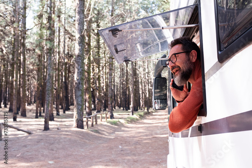 One man enjoying the view outside the window of a motorhome camper van enjoying vanlife and alternative travel vehicle vacation holiday. Freedom. Nomadic lifestyle people fulltimers. Free parking van