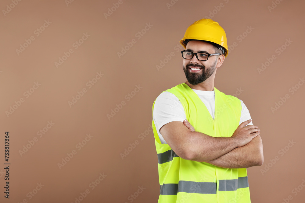 Engineer in hard hat on brown background, space for text