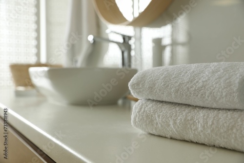 Stack of clean towels on countertop in bathroom. Space for text