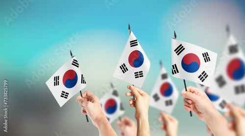 Fototapeta Naklejka Na Ścianę i Meble -  A group of people are holding small flags of South Korea in their hands.