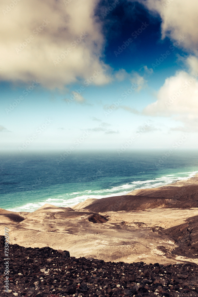 Obraz premium Awesome coastline landscape with ocean blue and mountains with horizon and clouds - beautiful world wild nature place for vacation and adventure summer