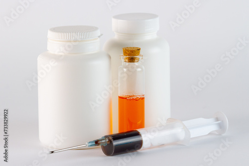 Medical ampoules and syringe on white background, closeup