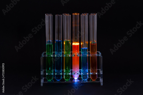 Laboratory test-tubes with colorful liquids on black background.