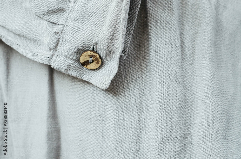 Close up coconut button on grey linen dress sleeve Close up coconut button on grey linen dress sleeve