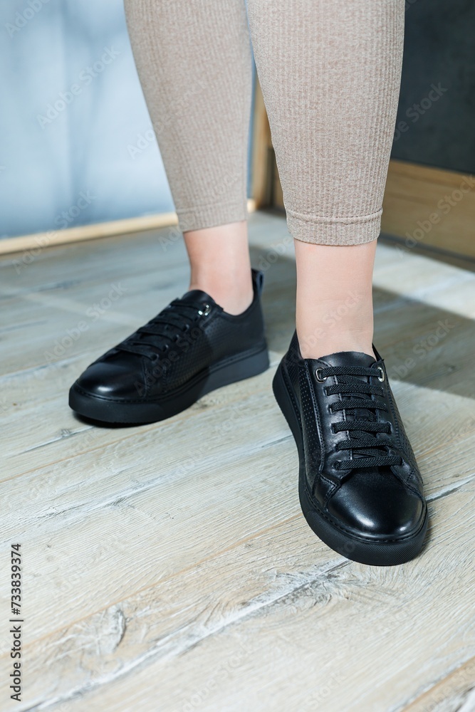 Collection of women's shoes. Black leather sneakers on women's feet. Female feet in comfortable casual sandals Collection of women's shoes. Black leather sneakers on women's feet. Female feet in comfortable casual sandals
