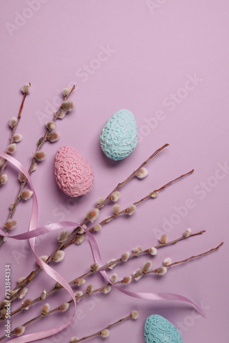 Pussy-willow twigs with Easter eggs on light purple background. Spring and Easter concept. Flat lay, top view. Space for text. photo