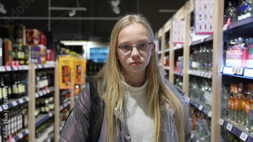 Concept of teenagers drinking problem. Young girl surrounded by alcohol drinks.
