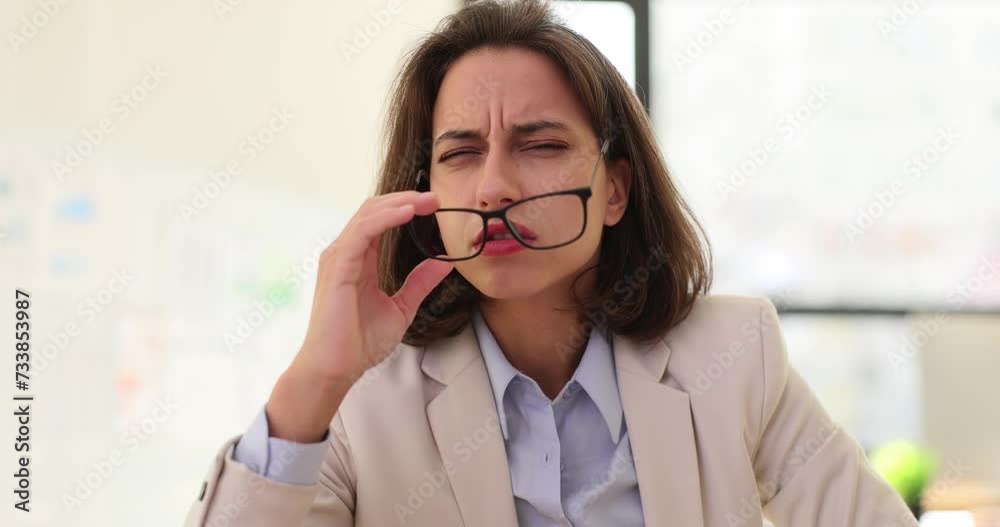 Woman removes glasses perplexed by unexpected turn of events Woman removes glasses perplexed by unexpected turn of events