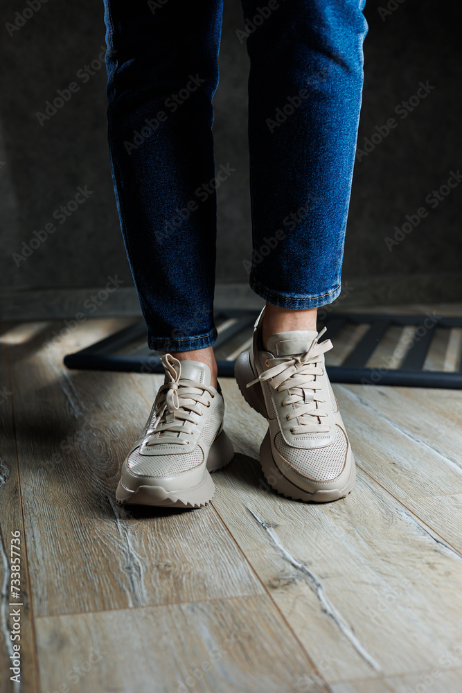 Beige women's sneakers. Collection of women's leather shoes. Female legs in leather beige casual sneakers. Stylish women's sneakers. Beige women's sneakers. Collection of women's leather shoes. Female legs in leather beige casual sneakers. Stylish women's sneakers.