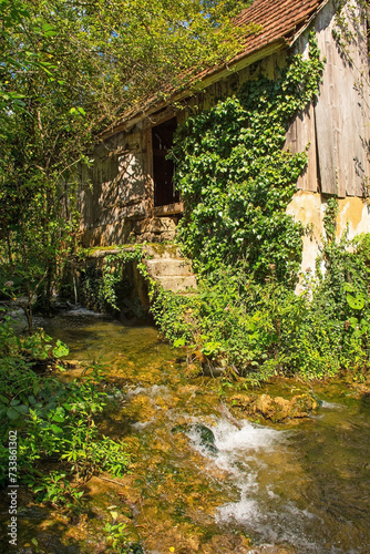 An abandoned derelict building next to a stream in Martin Brod in the Una National Park. Una-Sana Canton, Federation of Bosnia and Herzegovina. Early September