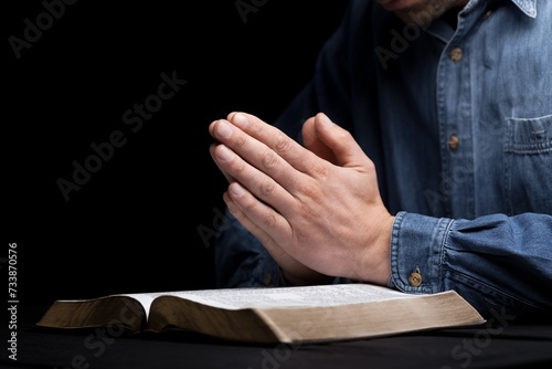 Hands of person folded for pray with Holy Bible © BillionPhotos.com