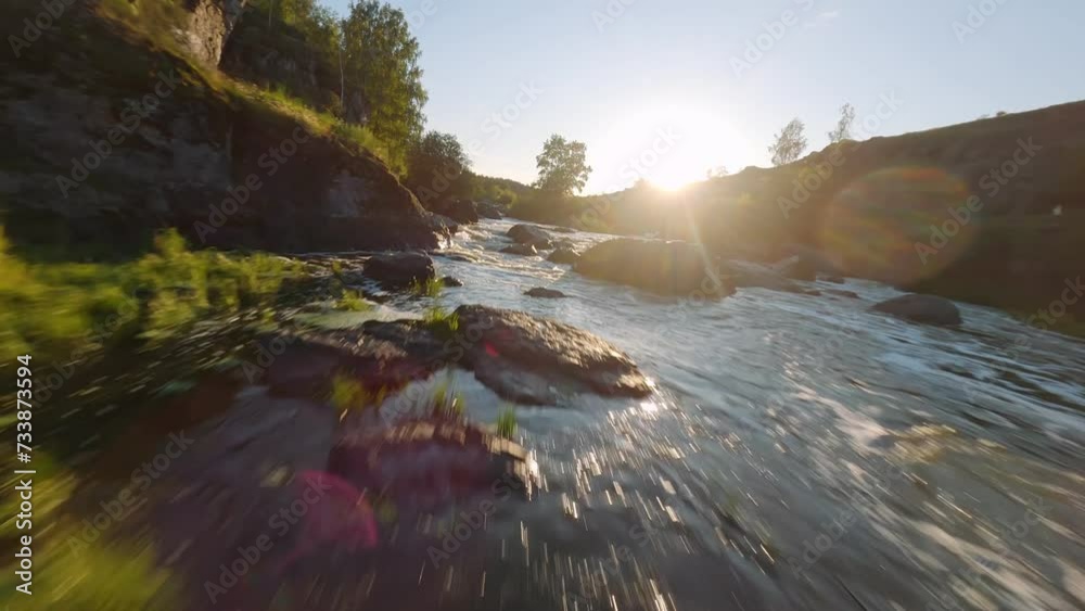 FPV Aerial shot flying a River Flowing Through a Verdant Forest in mountain. FPV Dynamic drone shot. 