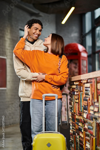 happy woman embracing her black boyfriend near reception desk in hostel, travel couple © LIGHTFIELD STUDIOS