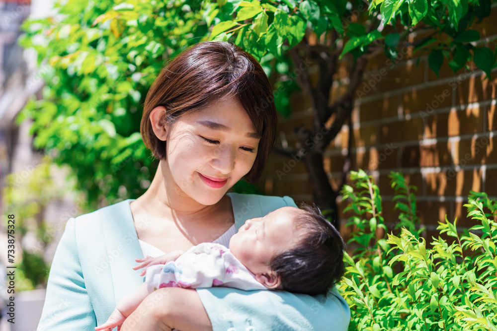 Fototapeta premium 赤ちゃんを抱きしめるキャリアウーマン