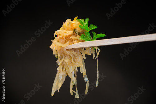 cabbage stewed with spices and carrots on a wooden fork