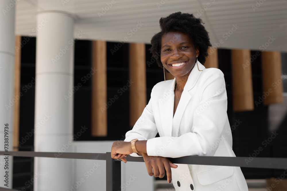 portrait of a happy curly African woman in a white suit portrait of a happy curly African woman in a white suit