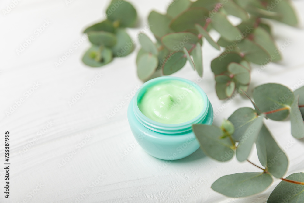 Jar of moisturizing cosmetic cream for face, hands and body with eucalyptus leaves on a white wooden background. Natural organic product. Beauty and spa concept. Body care. Space for text.Copy space. Jar of moisturizing cosmetic cream for face, hands and body with eucalyptus leaves on a white wooden background. Natural organic product. Beauty and spa concept. Body care. Space for text.Copy space.