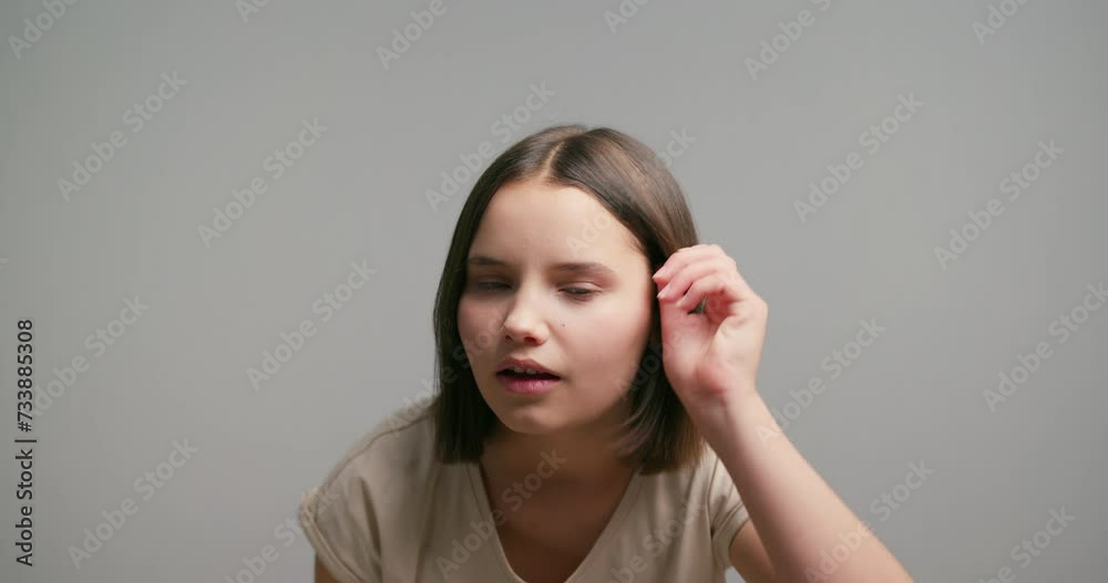 Shot of beautiful latin teen girl correcting make-up near mirror in the bathroom on gray background Shot of beautiful latin teen girl correcting make-up near mirror in the bathroom on gray background