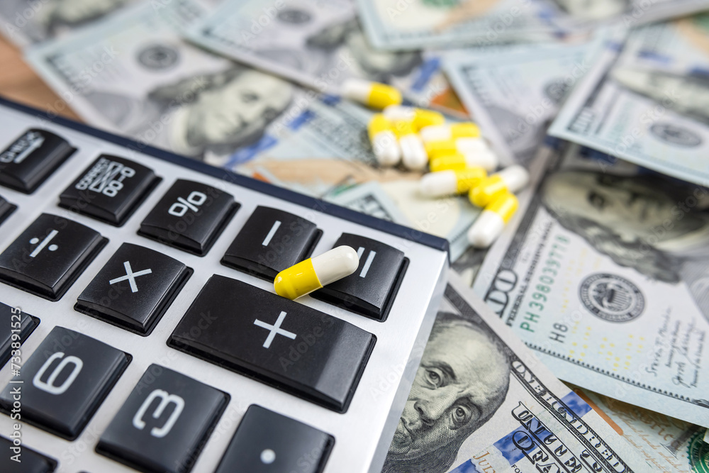 Fototapeta premium Dollar money with pills and calculator, concept for medical expenses