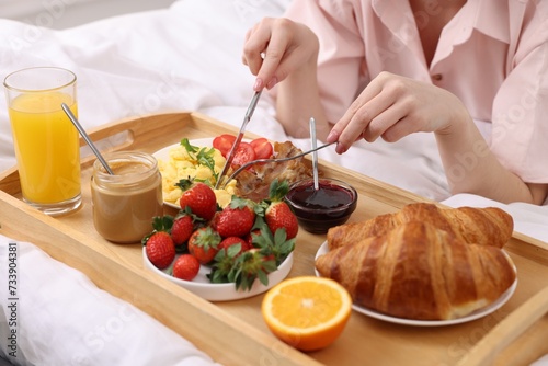 Woman having tasty breakfast on bed  closeup