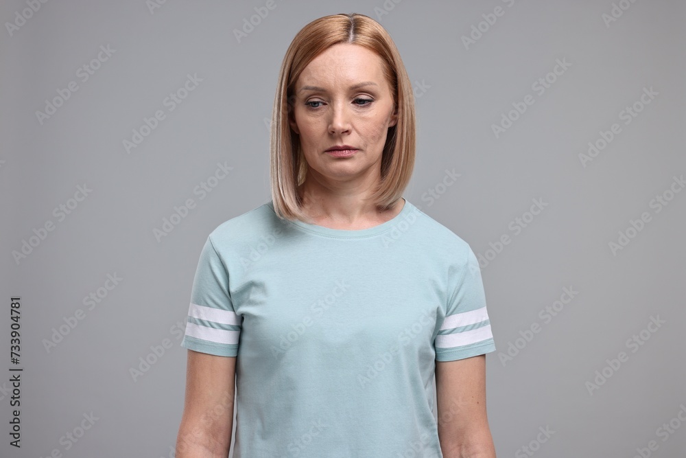 Portrait of sad woman on grey background Portrait of sad woman on grey background