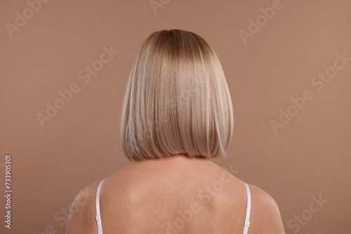 Woman with healthy skin on beige background, back view
