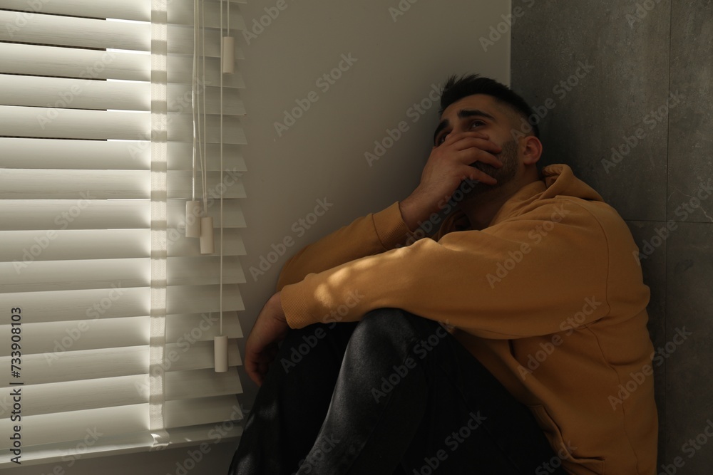 Sad man sitting near window. Space for text Sad man sitting near window. Space for text