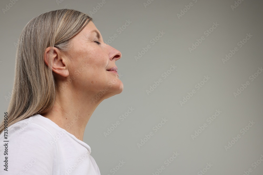 Beautiful woman with healthy skin on grey background, low angle view. Space for text Beautiful woman with healthy skin on grey background, low angle view. Space for text