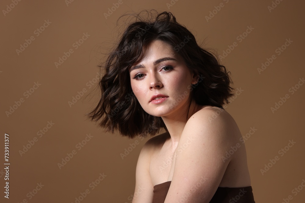 Portrait of beautiful young woman with wavy hairstyle on brown background. Space for text Portrait of beautiful young woman with wavy hairstyle on brown background. Space for text