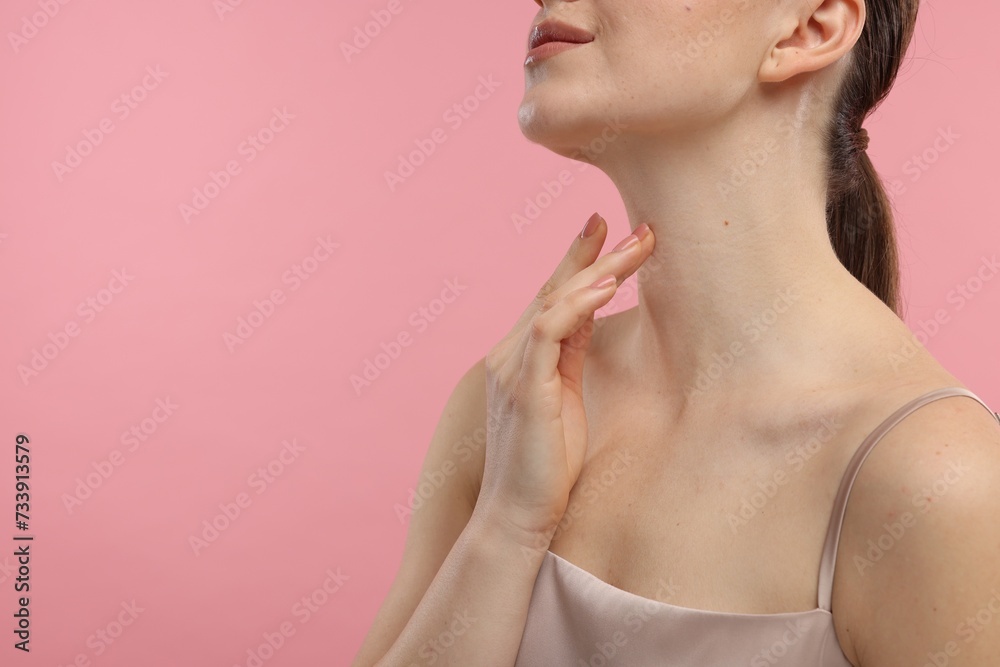 Woman touching her neck on pink background, closeup. Space for text Woman touching her neck on pink background, closeup. Space for text