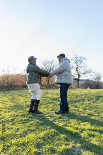 Senior couple holding hands  standing in meadow