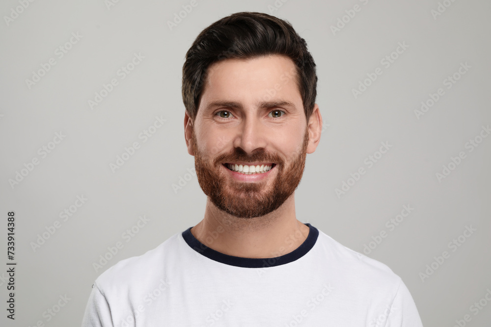 Portrait of smiling man with healthy clean teeth on light grey background Portrait of smiling man with healthy clean teeth on light grey background