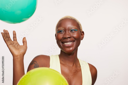 Smiling woman with short white hair, looking at balloons © Cultura Creative