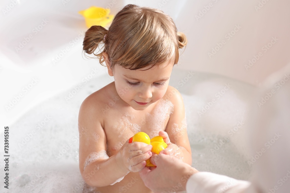 Mother playing with her little daughter in bath tub, closeup Mother playing with her little daughter in bath tub, closeup