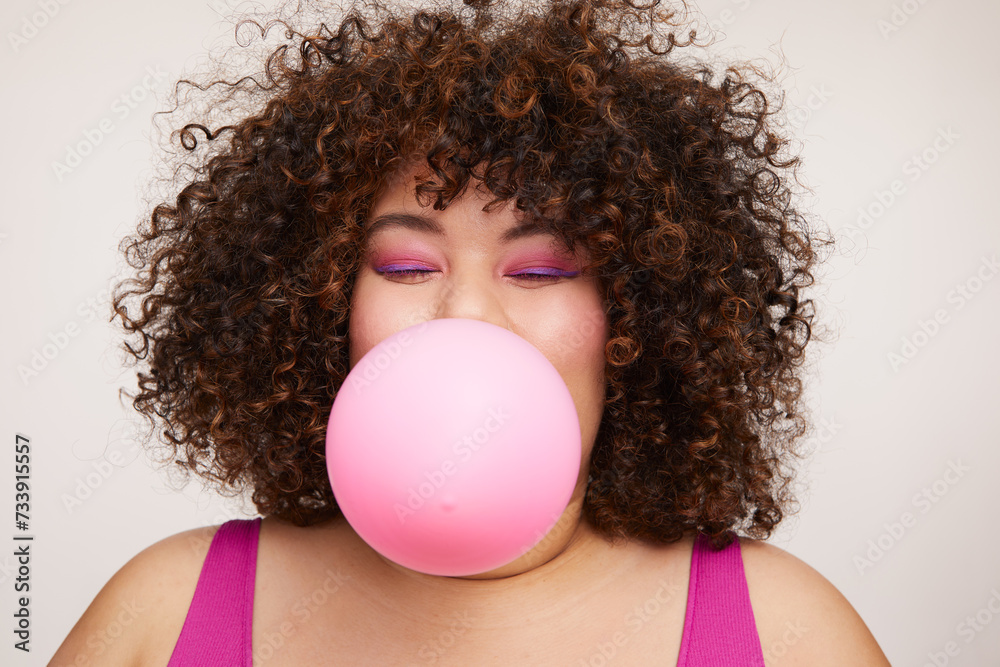 Brunette woman blowing pink balloon Brunette woman blowing pink balloon