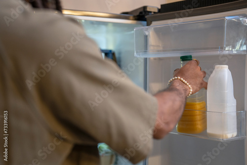 Man taking bottle of orange juice from fridge