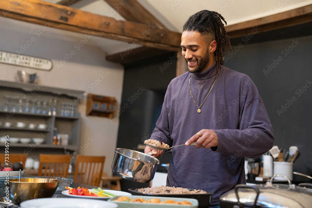 Fototapeta premium Smiling man cooking meal in kitchen 