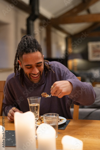 Smiling man eats dinner at table 
